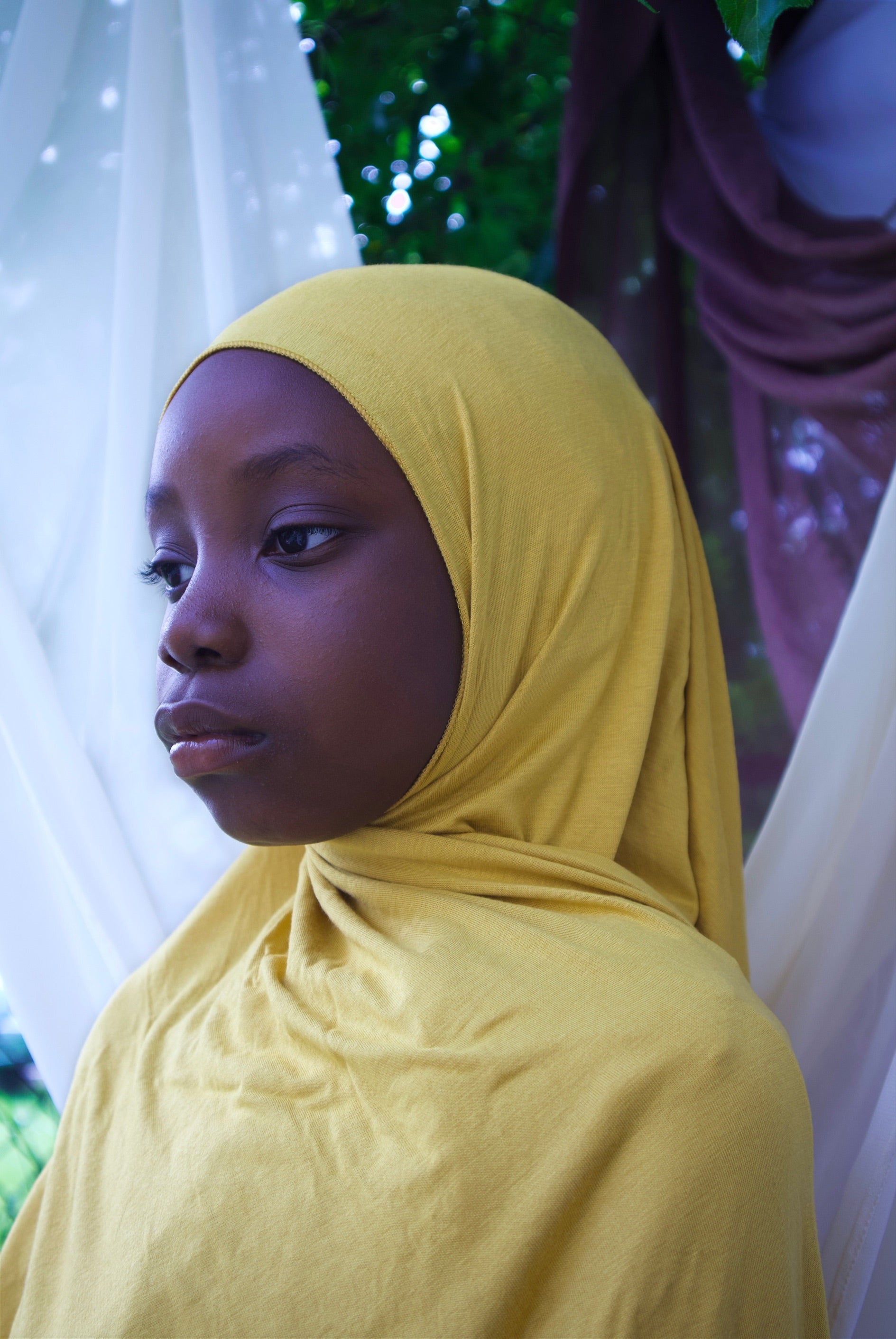 a little girl is wearin yellow instant jersey hijab